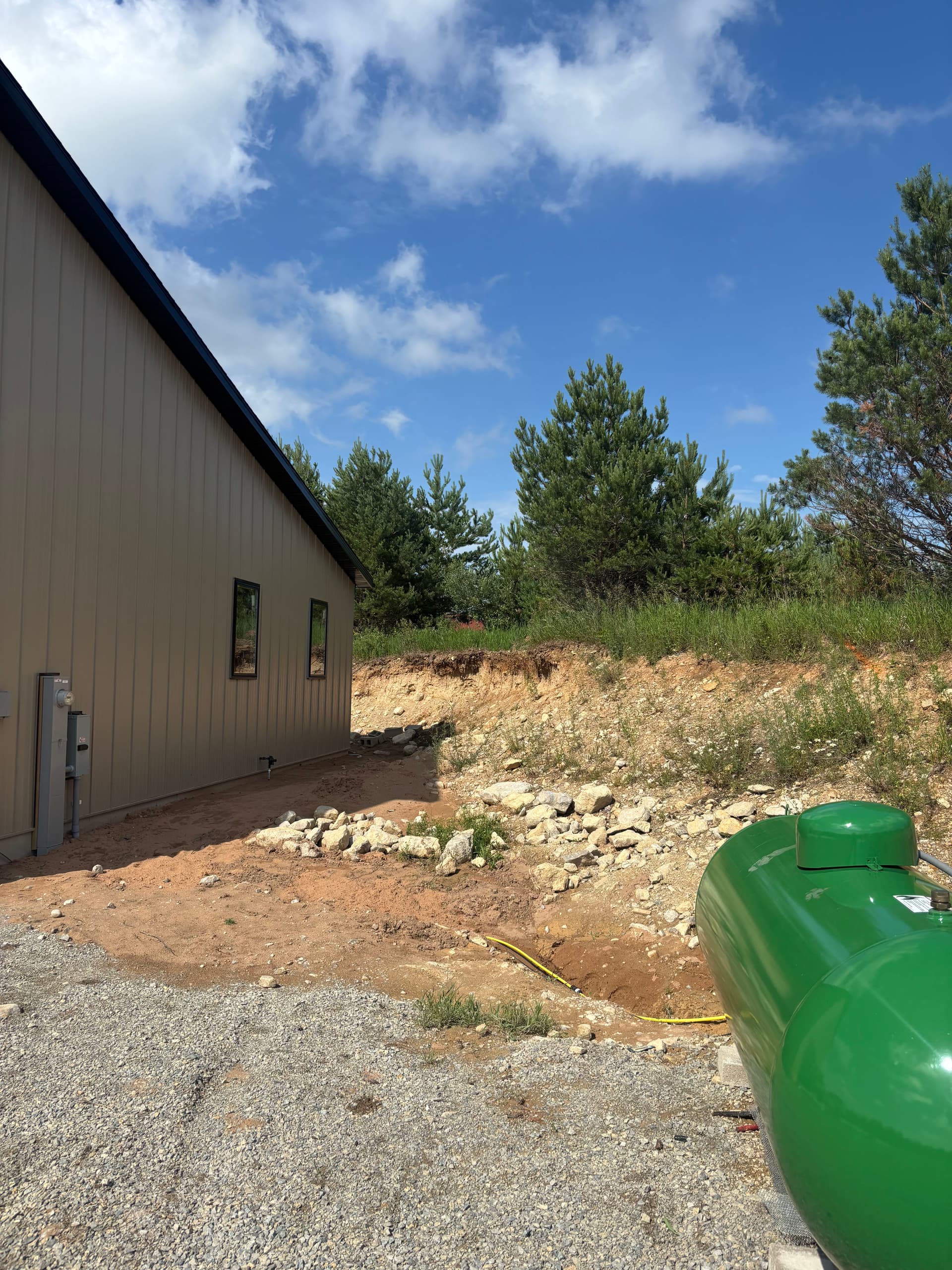 Slope Washout Fixed With Stone, Drainage, and Fresh Sod image